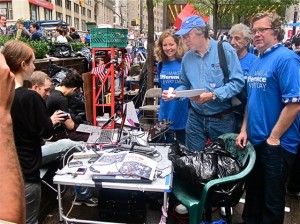 Kate McCaffrey, Rich Wolfson, Ahmet Baytas and Julian Brash handing the resolution to the media and labor table at Zuccotti Park