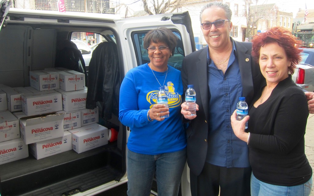 South Street Principal Karen George-Gray (left) and teacher Jeanette Campbell (right) welcome NTU president John M. Abeigon bringing a palette of water from NTU for the school